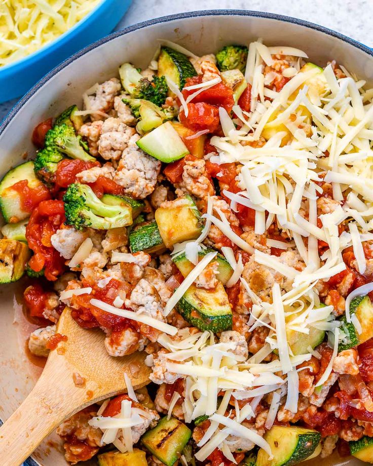 a bowl filled with zucchini, meat and cheese