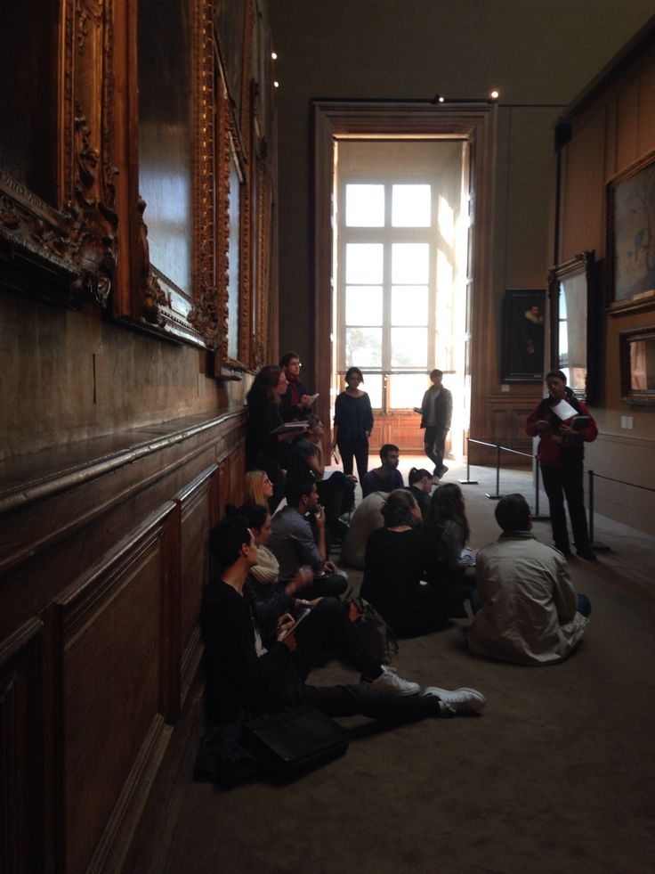 a group of people sitting on the floor in front of a door with an open window