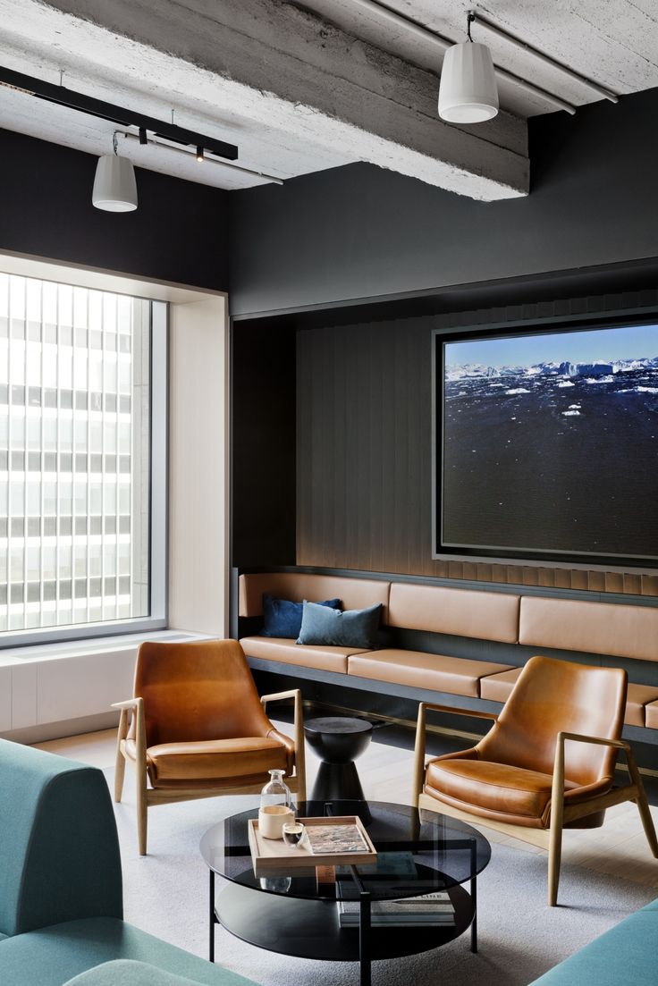 a living room filled with furniture and a flat screen tv mounted to the side of a wall