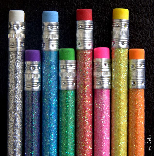 six different colored lighters lined up on a black surface with the same color in each one