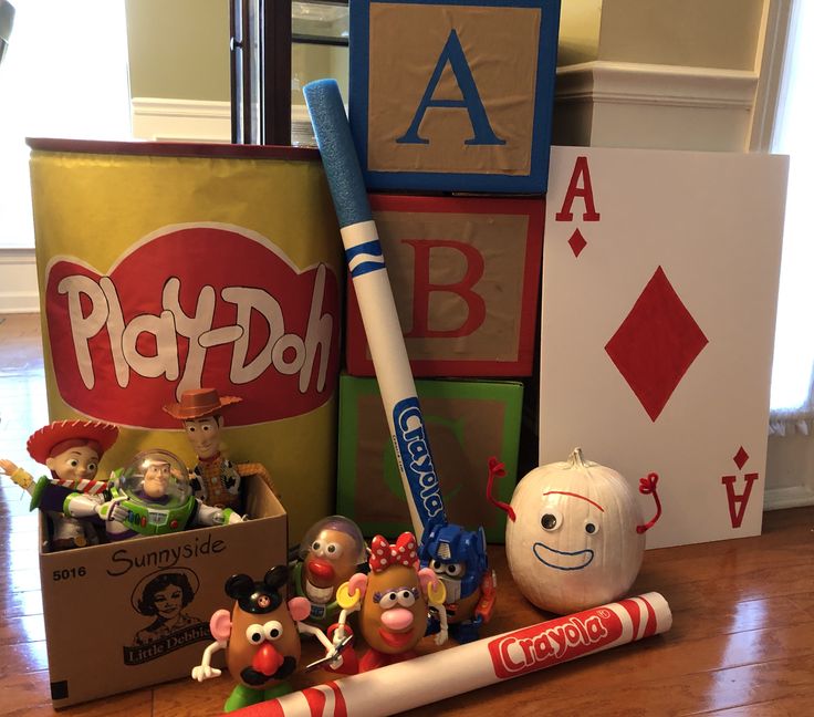 a group of toys sitting on top of a wooden floor next to a play doh sign