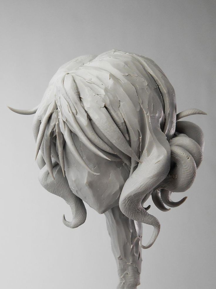 a sculpture of an animal with white paint on it's body and tail, in front of a gray background