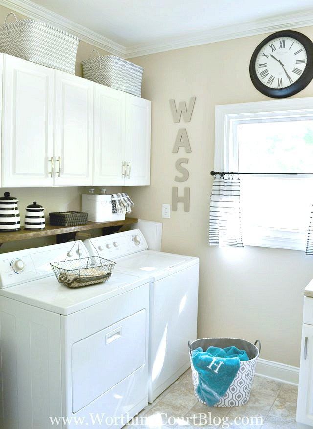 a white washer and dryer sitting in a kitchen next to a clock on the wall