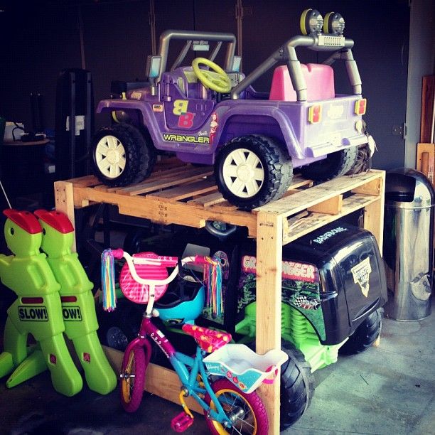 two toy cars are stacked on top of each other in a garage with children's toys