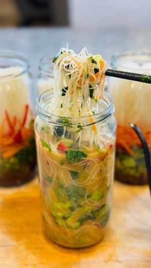 several jars filled with food on top of a wooden table