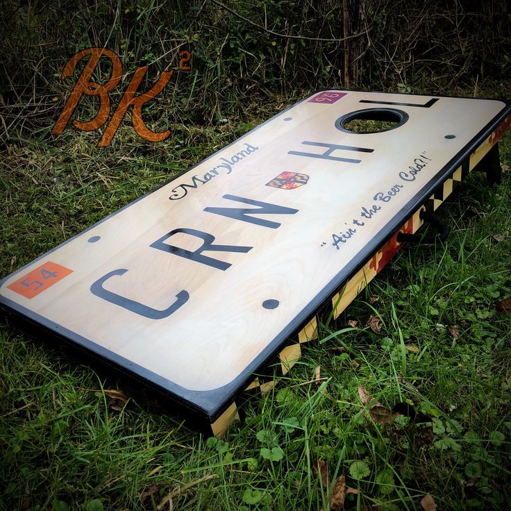 a close up of a cornhole board in the grass