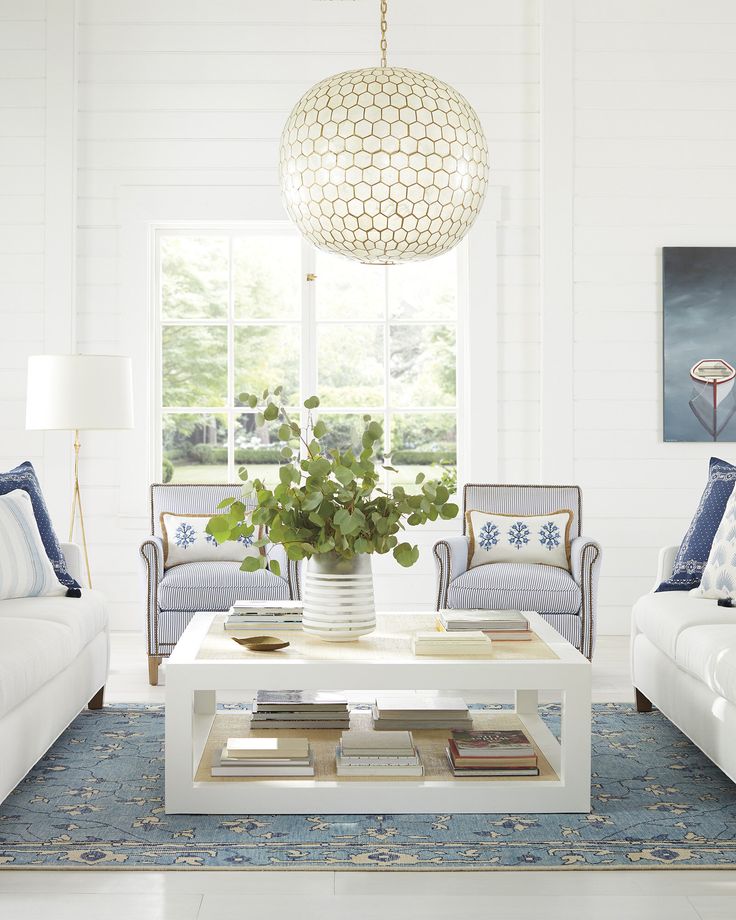 a living room filled with furniture and a white coffee table in front of a window