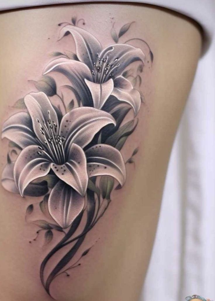 a woman's thigh with white flowers on the side and black lines around it