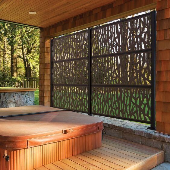 an outdoor jacuzzi is shown in front of a wooden wall and steps leading up to it