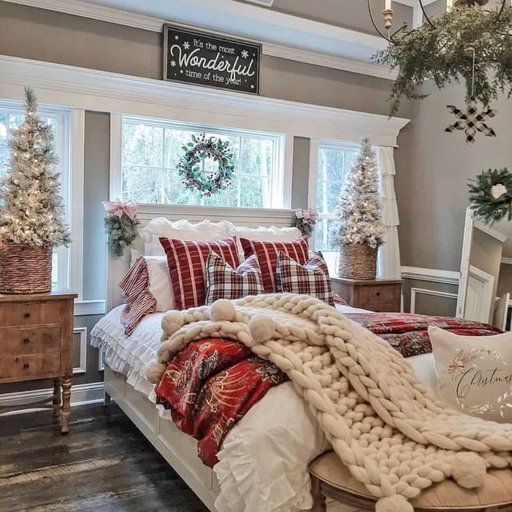 a bedroom decorated for christmas with white and red decorations on the windowsill, plaid bedding