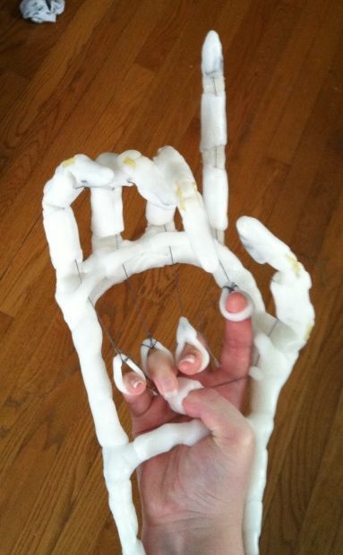 someone is making a fake house out of toilet paper and glue on the floor with their hands