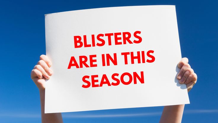 a person holding up a sign with the words blisters are in this season