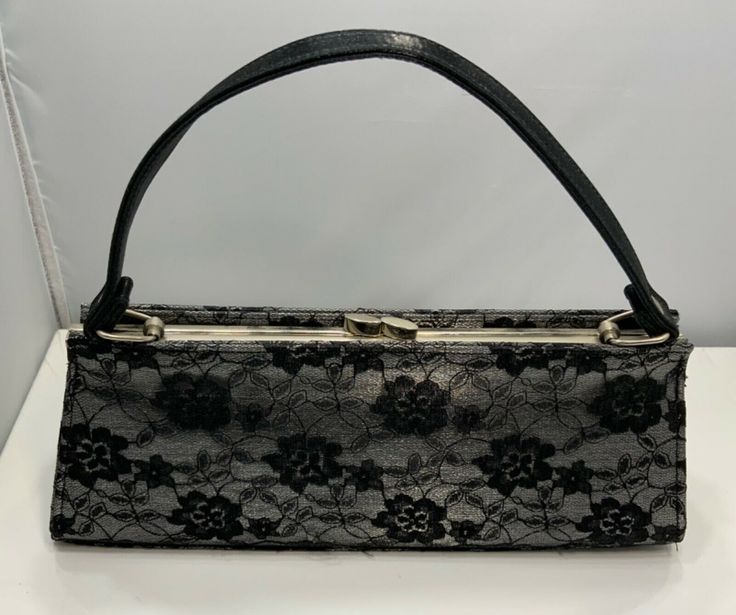 A LOVELY SILVER WITH BLACK LACE OVERLAY EVENING BAG/HANDBAG/PURSE. HAS A SHORT BLACK HANDLE AND A LONG 46” STRAP SO IT CAN BE USED AS  CROSSOVER BAG. PREVIOUSLY OWNED IT IS IN EXCELLENT CONDITION. PLEASE  VIEW ALL PHOTOS CAREFULLY BEFORE BIDDING OR BUYING. THEY ARE CONSIDERED PART  OF THE DESCRIPTION. THANK YOU FOR YOUR CONSIDERATION! Lace Purse, Crossover Bag, Lace Bag, Crossover Bags, Evening Handbag, Black Handle, Handbag Purse, Lace Overlay, Kate Spade Top Handle Bag