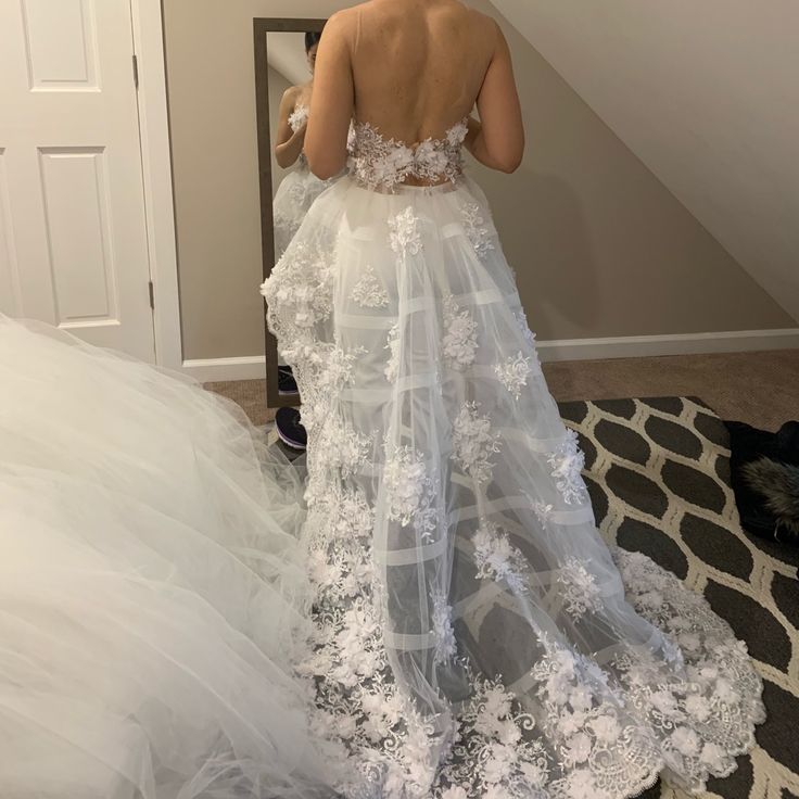 a woman in a wedding dress looking at herself in the mirror