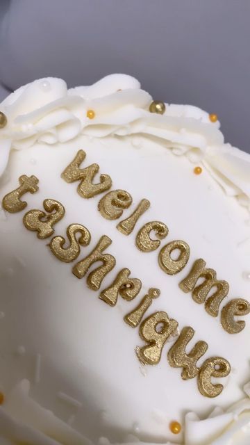 a white cake with gold lettering on it