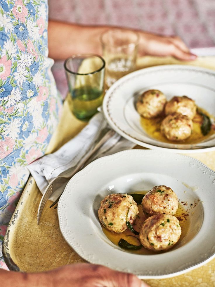 two plates filled with food on top of a yellow cloth covered tablecloth next to silverware