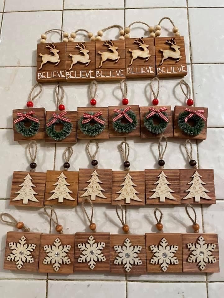 christmas ornaments are hanging on the wall in front of a tile floor with words above them