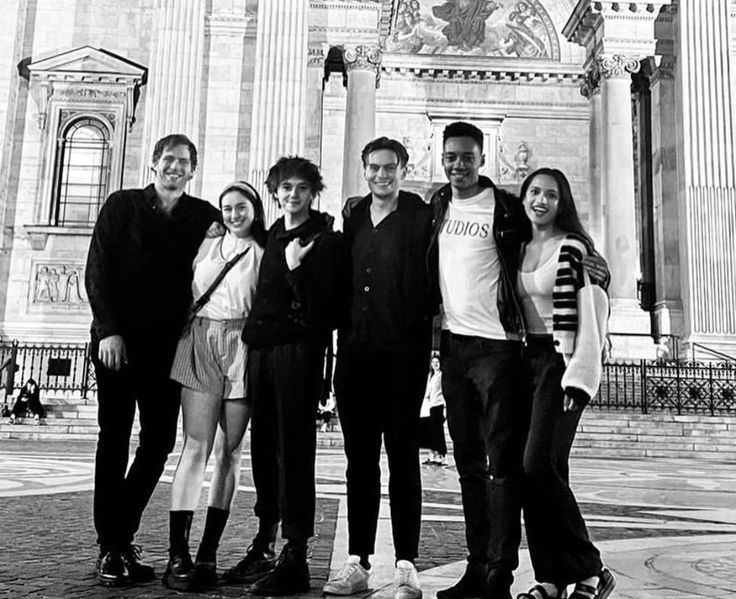 a group of people standing next to each other in front of a building