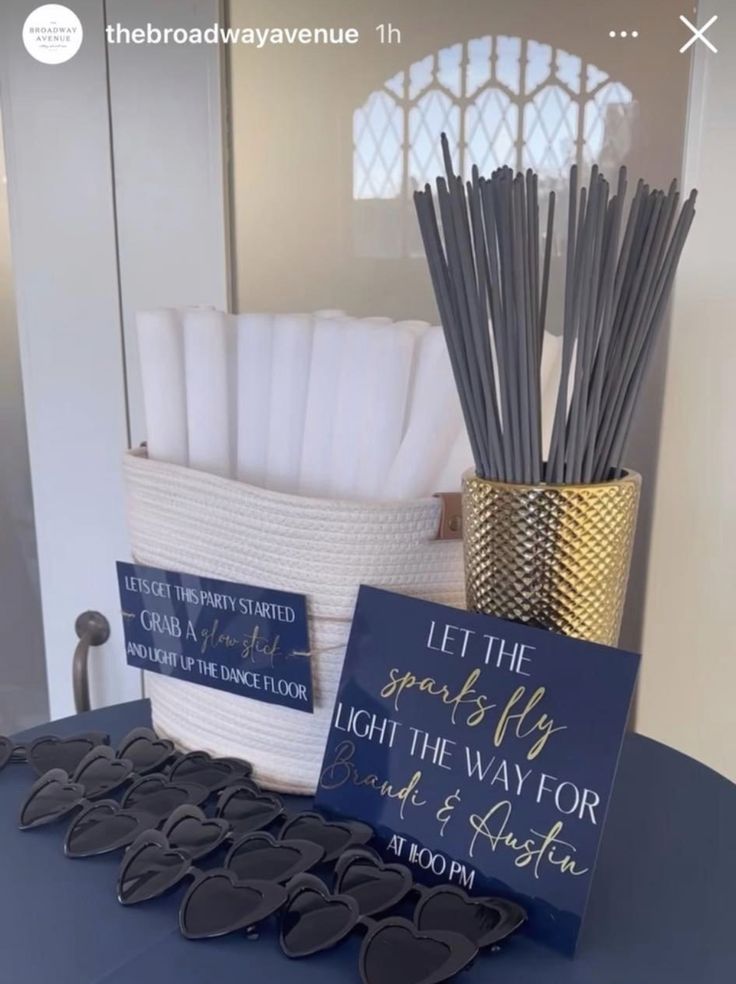 a table topped with sunglasses and a sign that says let the sparkle fly light the way for each other