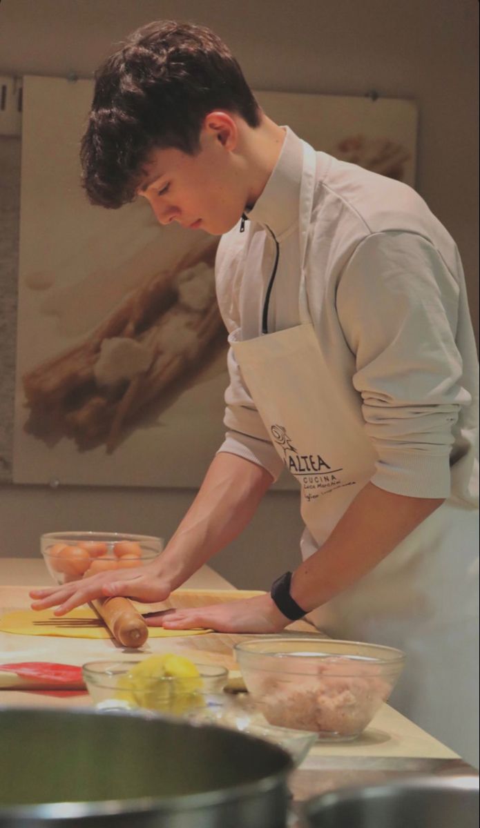 a young man is preparing food in the kitchen