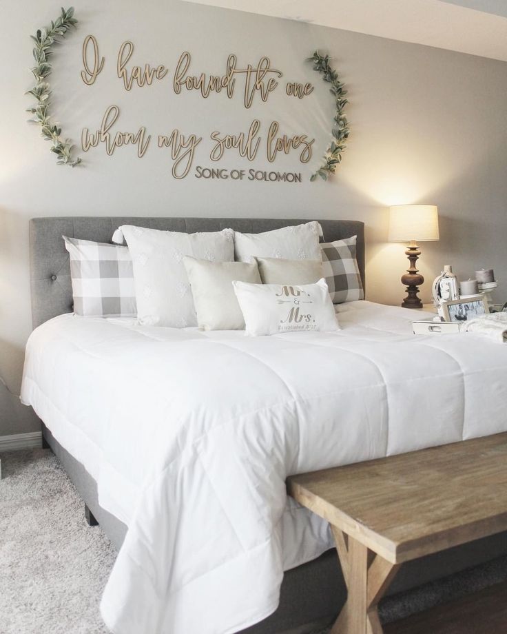 a bed with white sheets and pillows on top of it next to a wooden bench