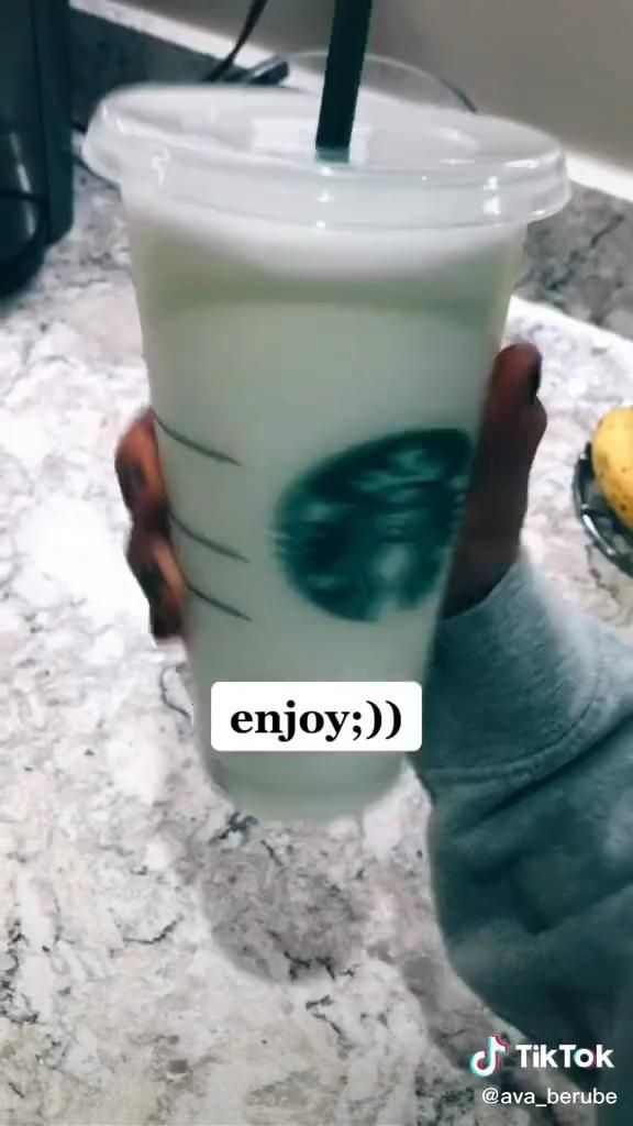 a person holding up a cup filled with liquid