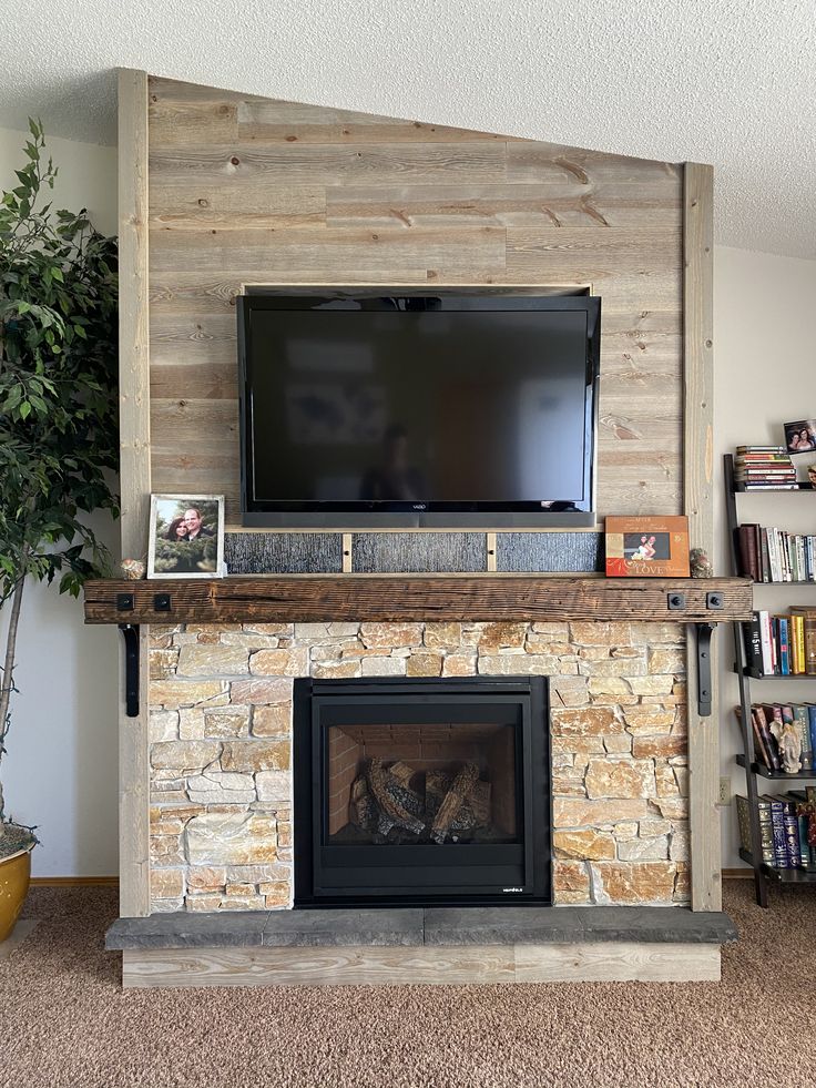 a flat screen tv mounted on top of a stone fireplace