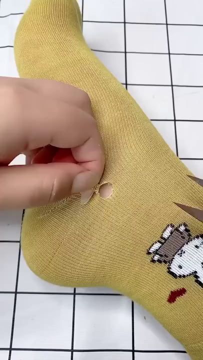 someone is cutting through the bottom of a sock that has a cartoon character on it