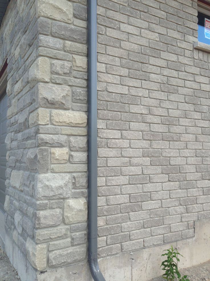 a fire hydrant sitting on the side of a brick building