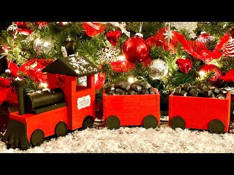 a christmas tree decorated with red and silver ornaments, train ornament and other holiday decorations