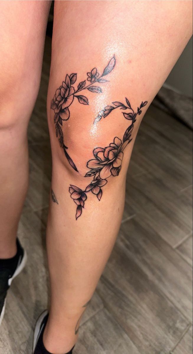 a woman's legs with flowers and leaves on them in the shape of a heart