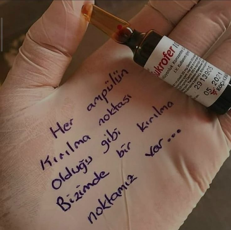 a hand with writing on it holding a bottle of medicine