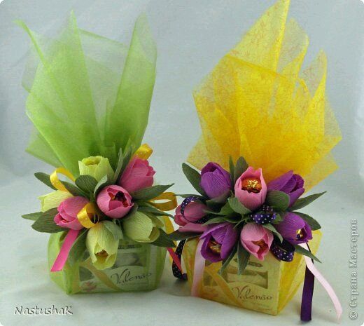 two small vases filled with flowers on top of a table