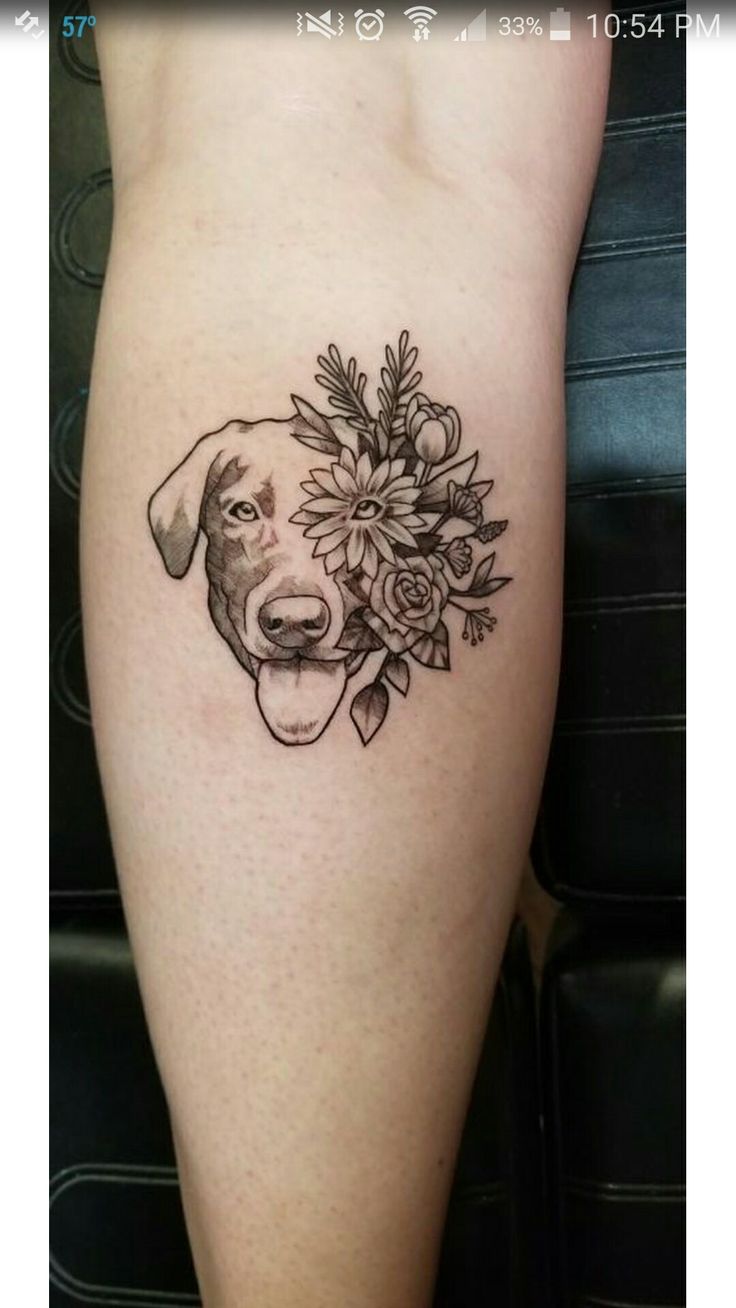 a black and white photo of a dog with flowers on it's side leg