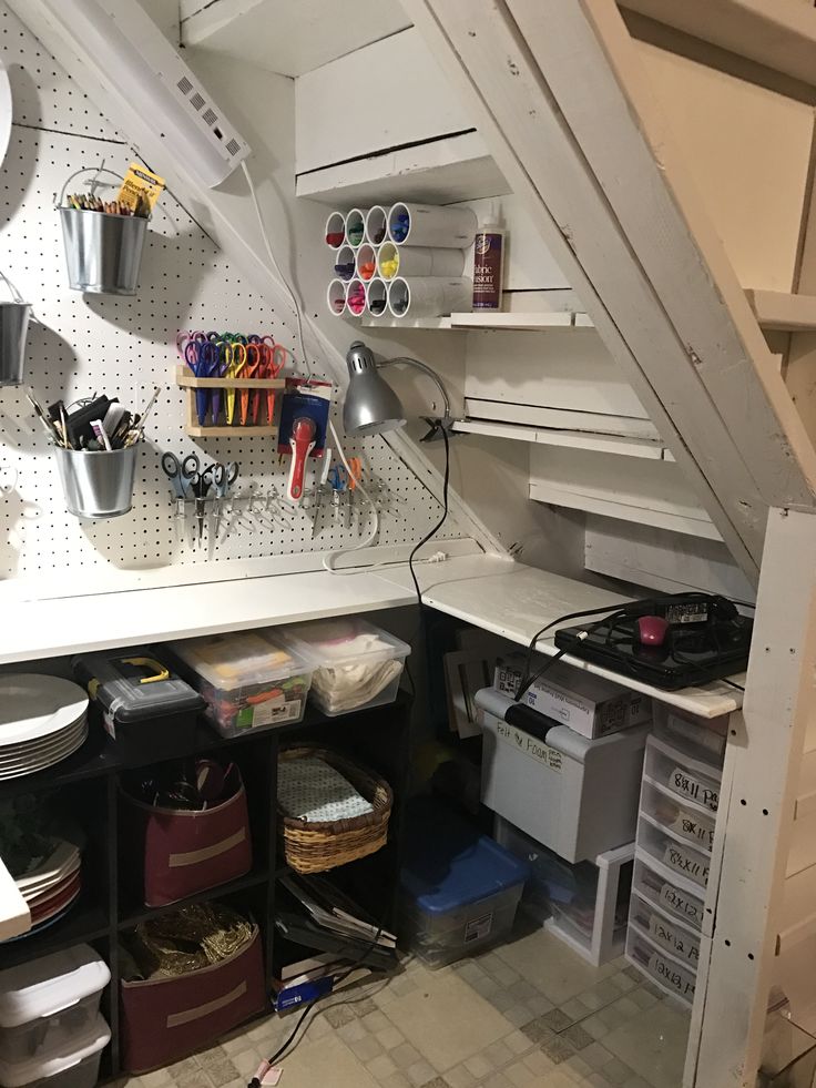 an organized craft room under the stairs with lots of tools and supplies on it's shelves