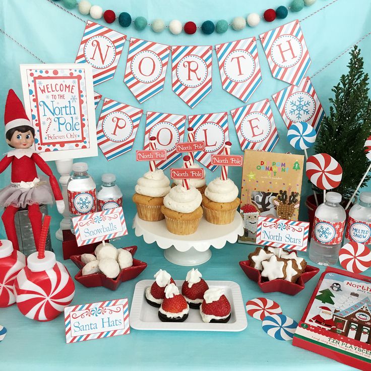 an elf is sitting in front of a table with cupcakes and desserts