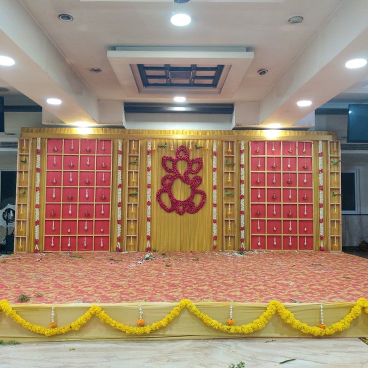 the stage is decorated with yellow and red flowers, gold trimmings and decorations