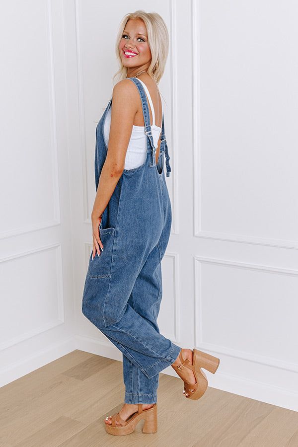 - Show off your trendy style with this cute jumpsuit! It is the perfect piece for a casual look that has that wow factor you have been looking for. - Unlined non-stretch denim material - Straps that lace through a silver colored buckle for adjustable length - A scoop back - Functional back pockets - A relaxed silhouette that ends in straight hemlines