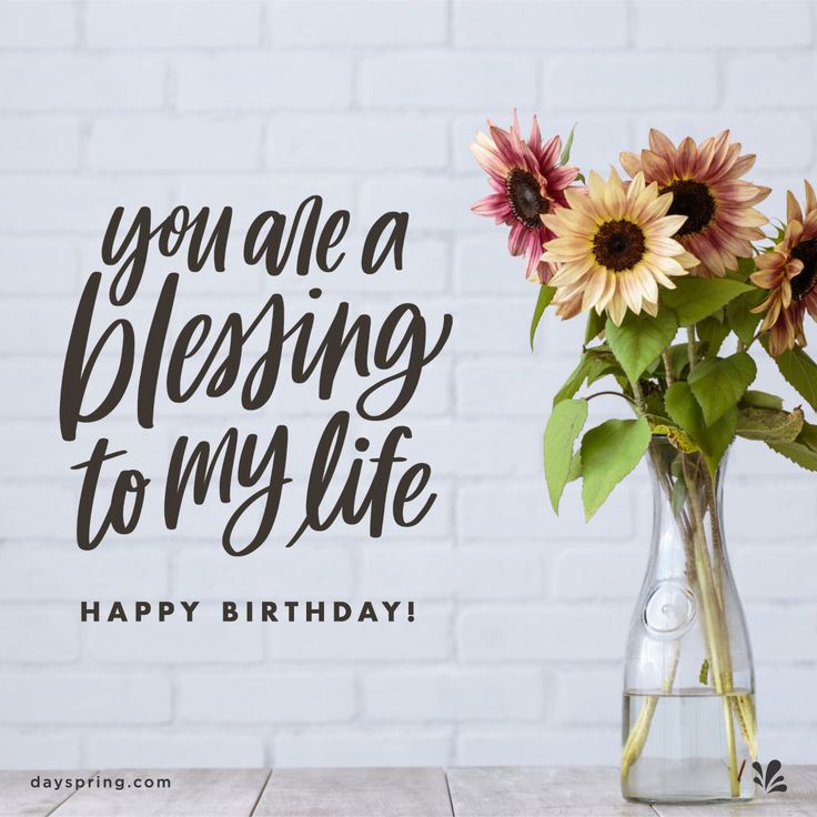 a vase filled with sunflowers sitting on top of a table next to a brick wall