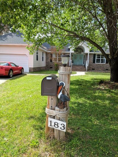 a mailbox in the grass near a house