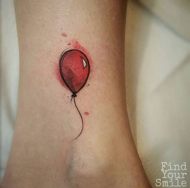 a small red balloon tattoo on the ankle