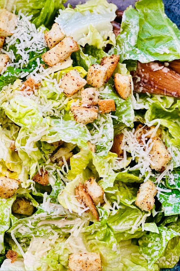 a salad with lettuce, croutons and parmesan cheese