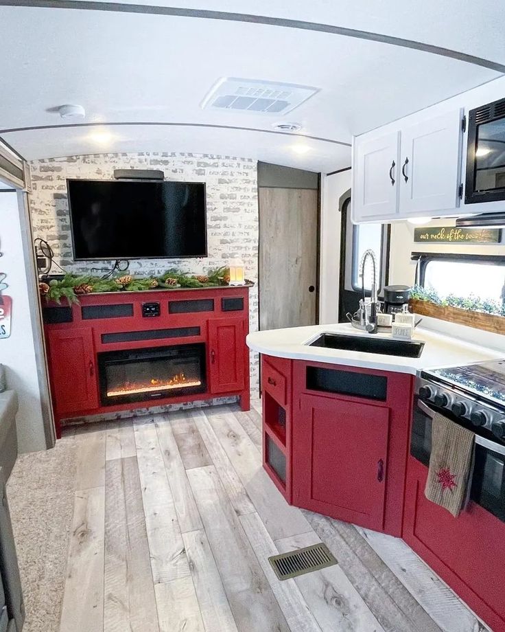 a kitchen with red cabinets and an oven in the center is decorated with christmas decorations