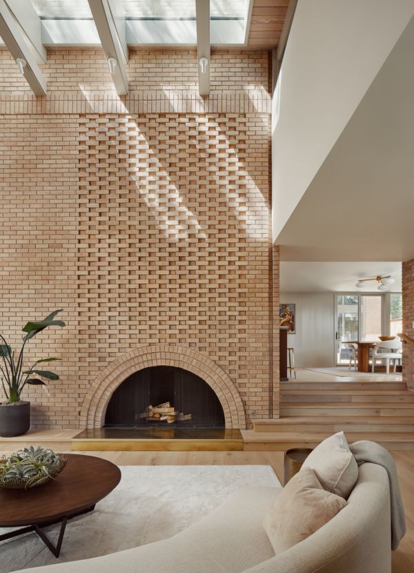 a living room filled with furniture and a fire place in the middle of an open floor plan