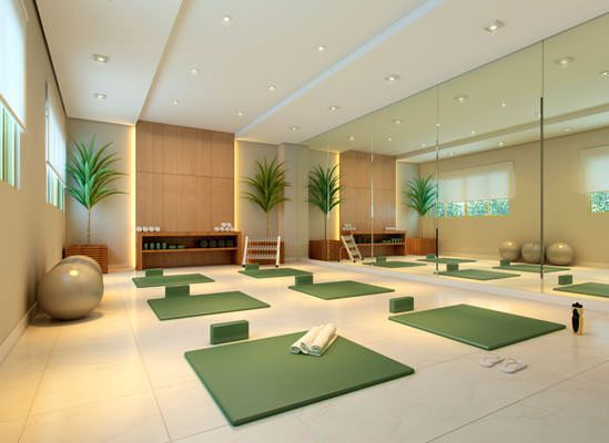 a room with yoga mats and exercise balls on the floor in front of large mirrors