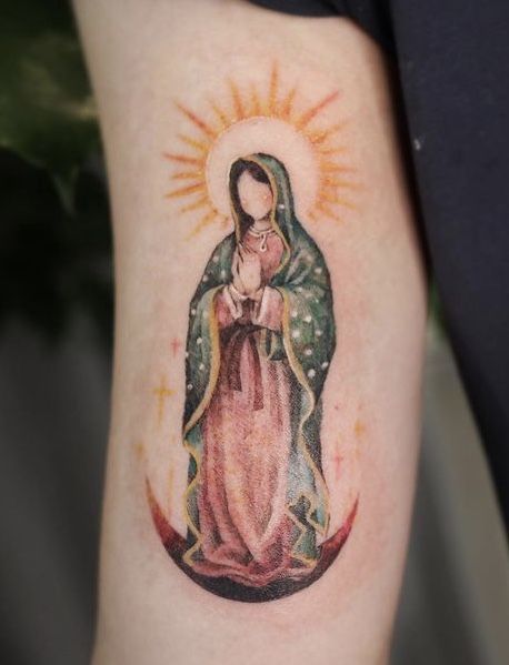 a woman's arm with a tattoo on it that has an image of the virgin mary