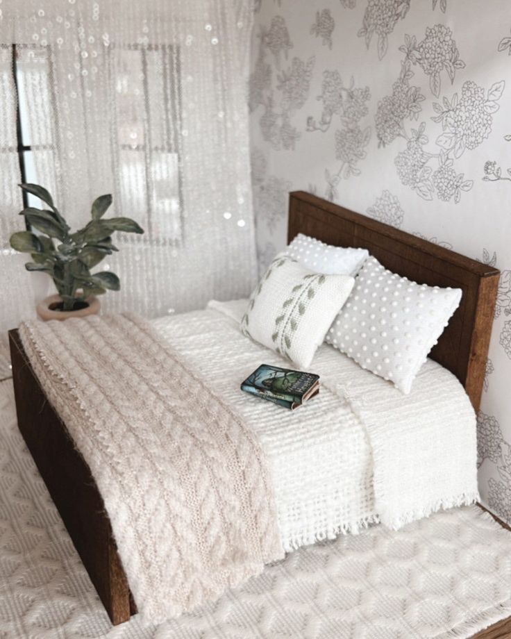 a bed with white sheets and pillows in a bedroom next to a wallpapered wall