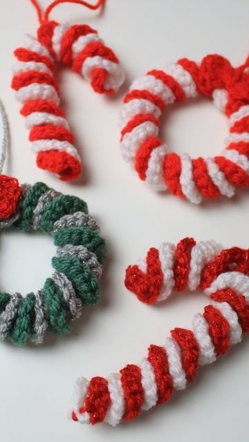 crocheted christmas wreaths and ornaments are displayed on a white surface with yarn