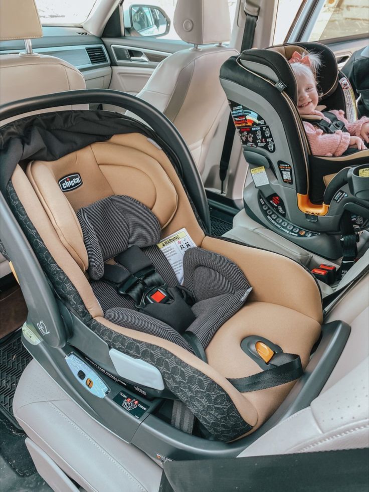 a baby in a car seat inside of a vehicle