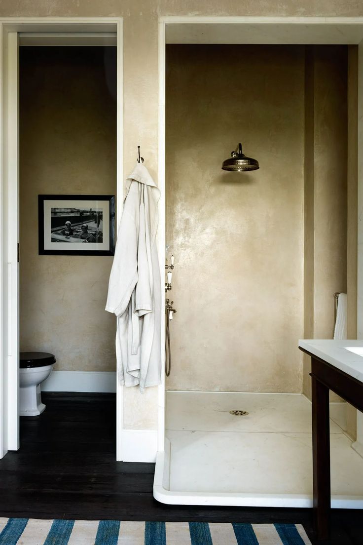 an open door leading to a bathroom with a sink and toilet in the shower stall